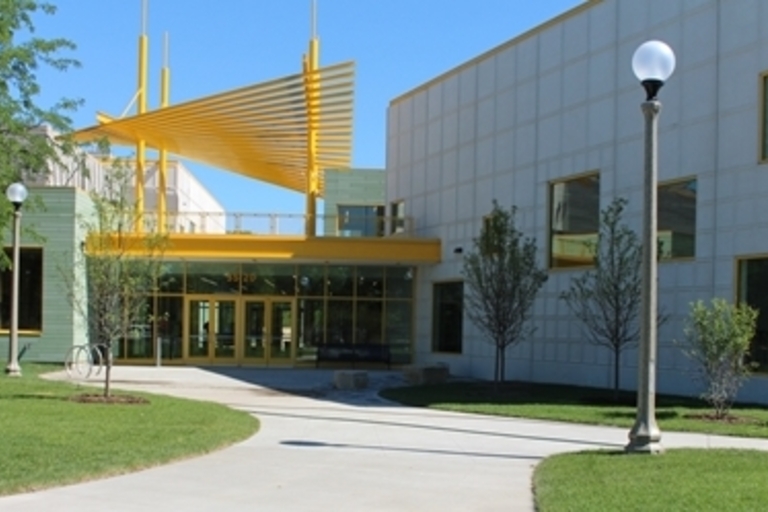 Modern school building with yellow entrance awning.