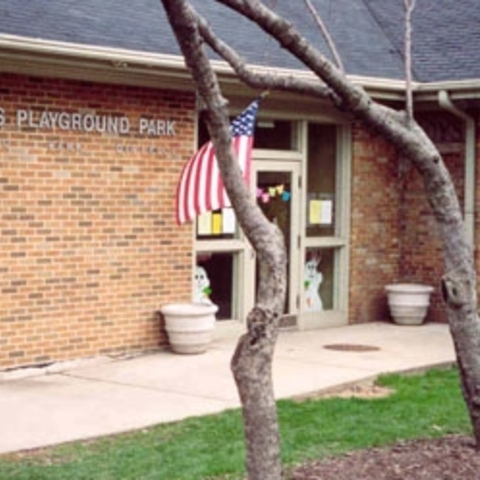 Adams Playground Park building exterior with US flag.