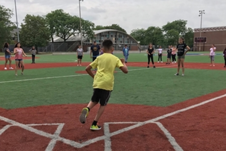 Child running on a baseball field.