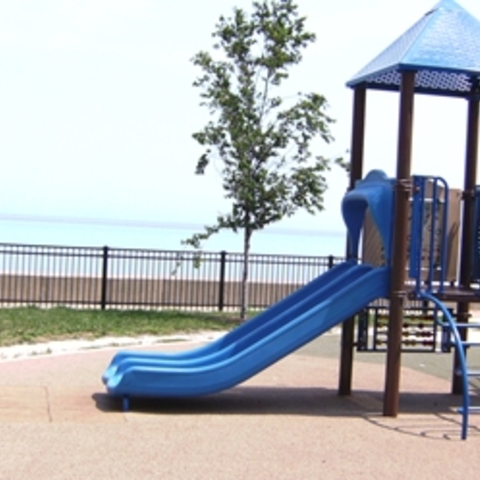 Blue playground next to a lake.
