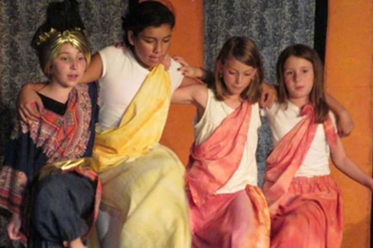 Four children in costume perform a play.
