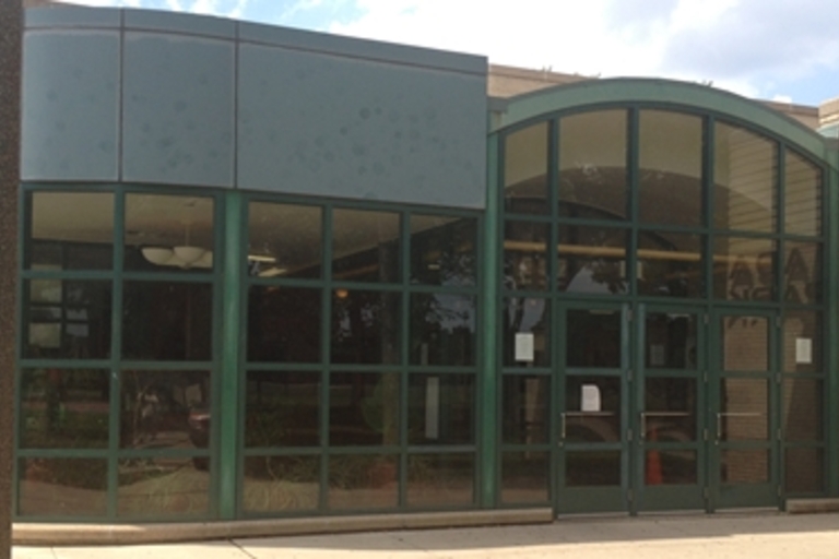 Ada Park building exterior with green-framed windows and doors.