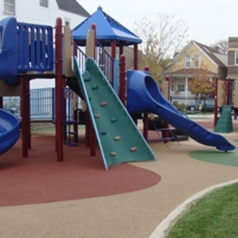 Colorful playground with slides and climbing wall.

