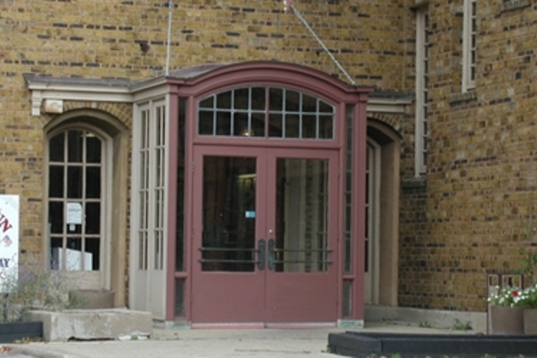 Red double doors of brick building entrance.