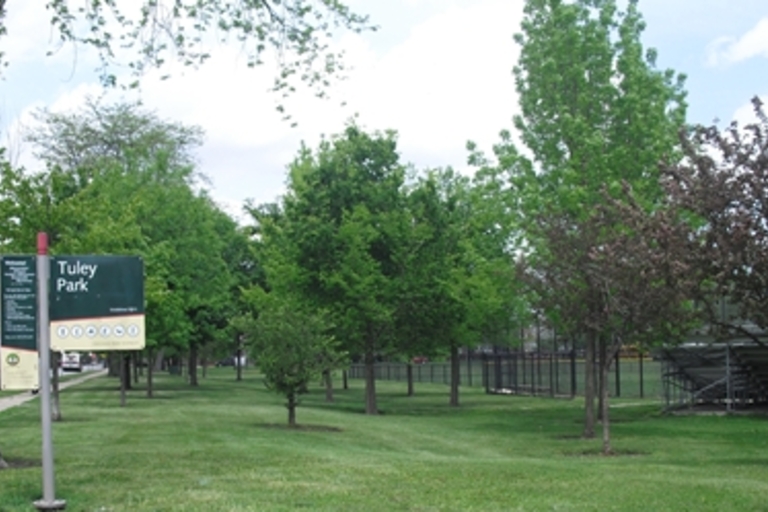 Tuley Park sign and grassy area with trees.