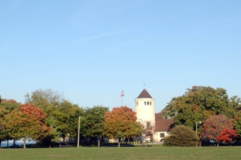 Autumn trees frame a building with a tower.
