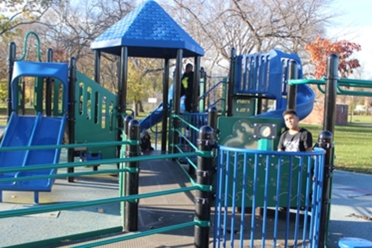 Children play on a blue and green playground.