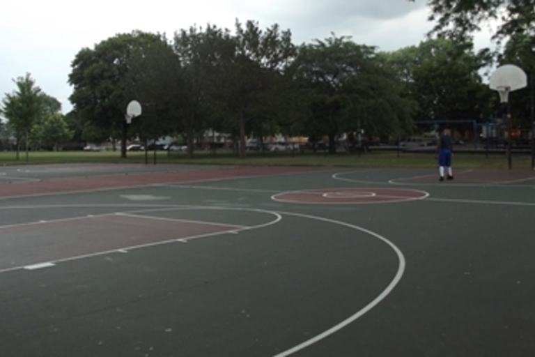 Outdoor basketball court on a cloudy day.