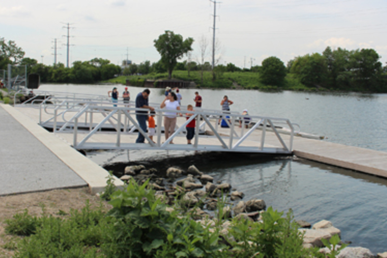 Families fish from an accessible pier on a lake.