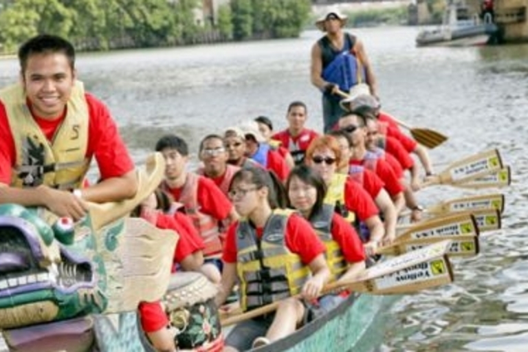 Dragon boat team paddling down a river.
