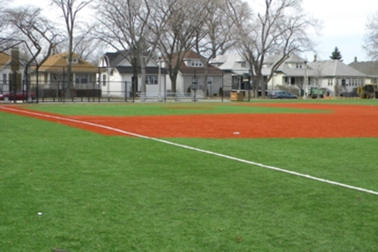 Empty baseball field with artificial turf infield and outfield.