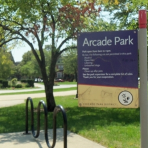 Arcade Park sign with bike rack and park in the background.
