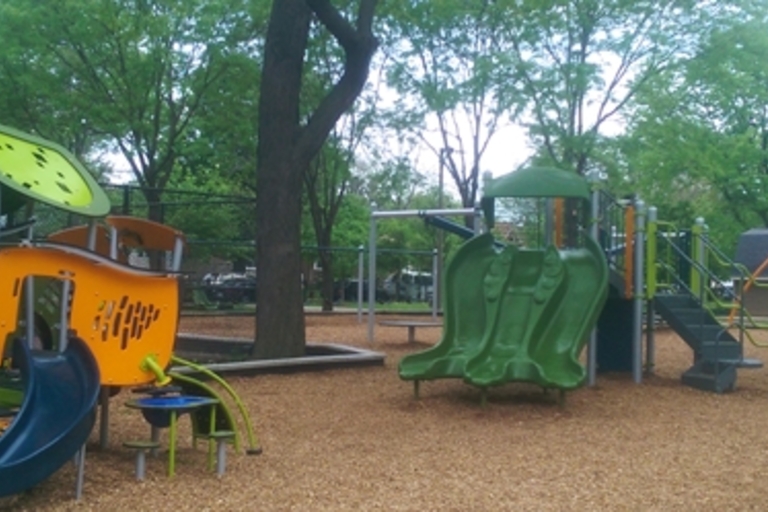 Colorful playground equipment on wood chips.
