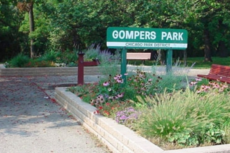 Gompers Park sign by flower garden and benches. Chicago Park District.