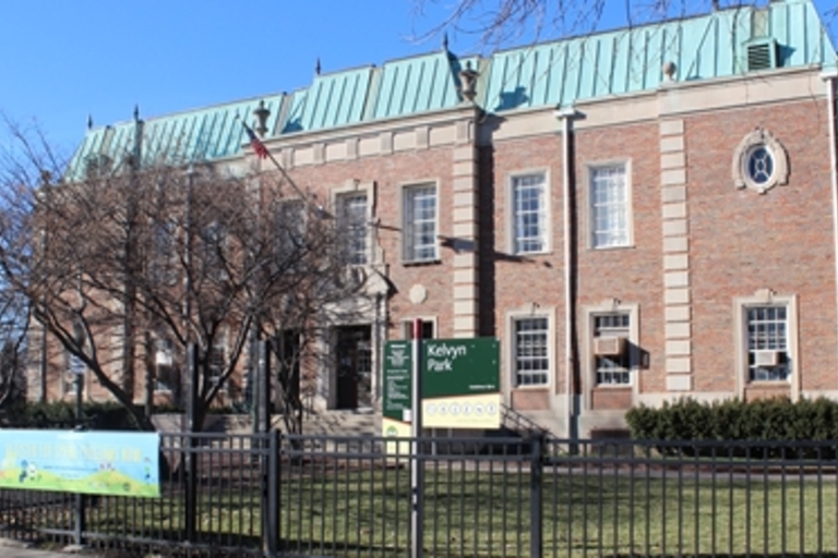 Kelvin Park fieldhouse behind a short fence.