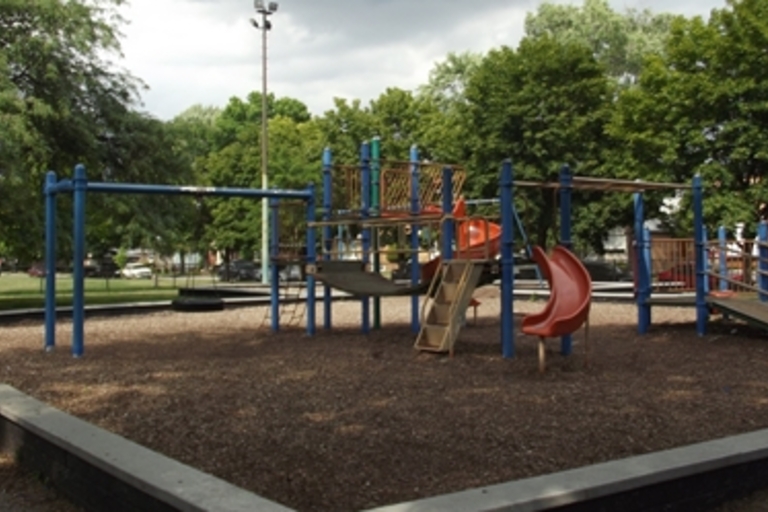 Playground with slides and climbing structures on wood chips.