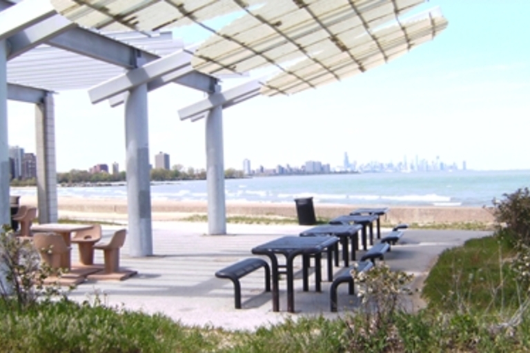 Picnic area on a beach with Chicago skyline in the distance.