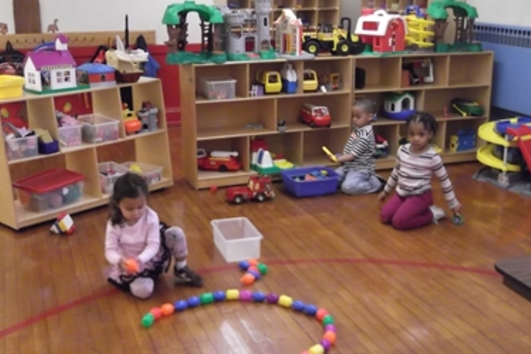 Children play with colorful toys in a playroom.
