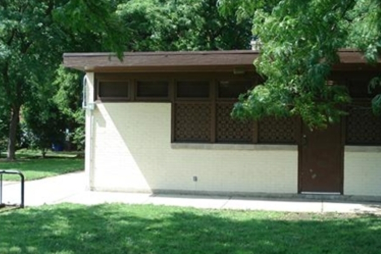 Park restroom building with brown door and decorative vents.