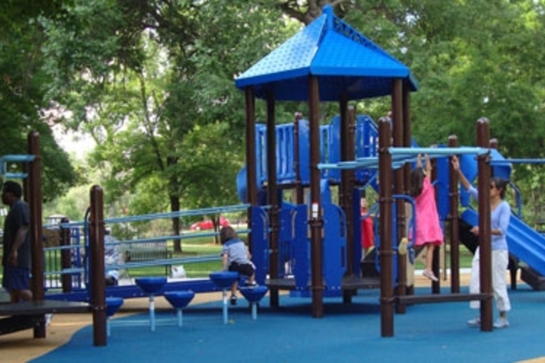 Children play on a blue and brown playground with a soft, blue surface.
