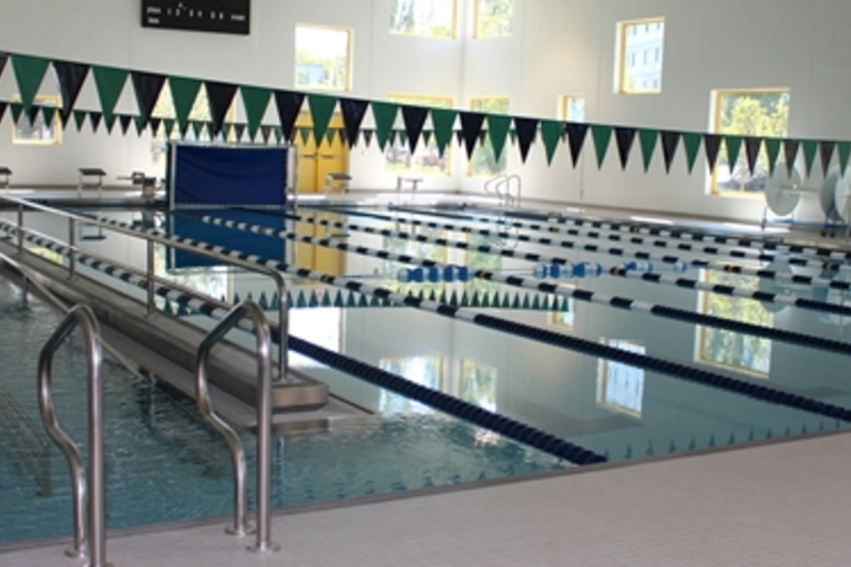 Indoor competition swimming pool with lane markers and access ramp.
