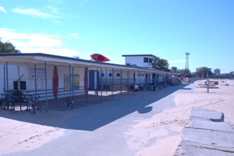 Beachside kayak rental shop with a few bikes parked out front on a sunny day.