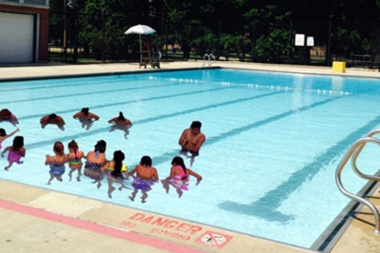 Children learning to swim in a public pool.
