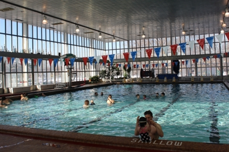 Indoor swimming pool with people enjoying the water.