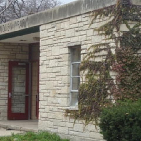 Raymond Elementary School exterior with stone and brick walls, partially covered in vines.