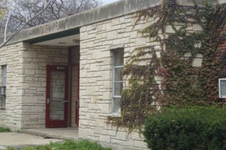 Raymond Elementary School exterior with stone and brick walls, partially covered in vines.