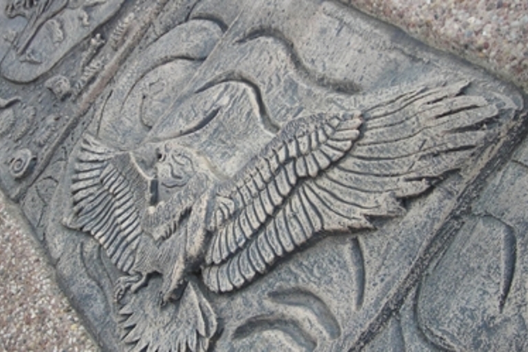 Stone carving of a bird in flight.