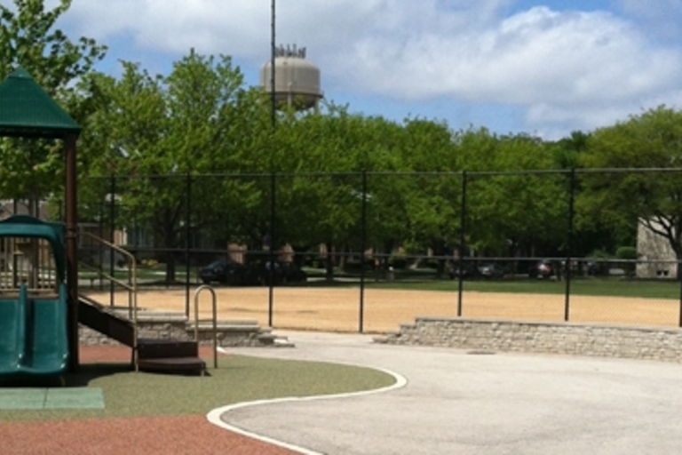 Playground with baseball field and water tower in background.