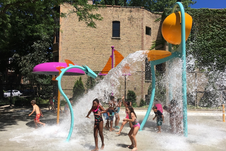 Children play in a splash park on a sunny day.