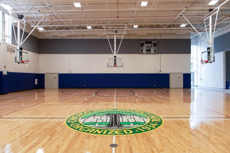 Empty indoor basketball court with polished wooden floor and Chicago Park District logo.