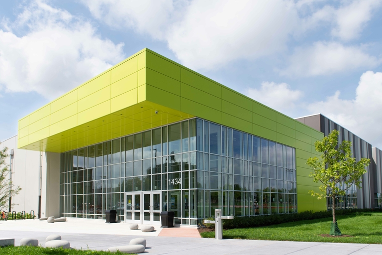 Modern building with lime green panels and large glass windows.