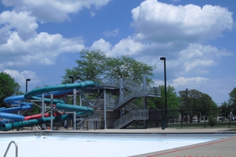 Colorful waterslides at a public pool on a sunny day.