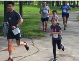 Runners of all ages participate in a park race.