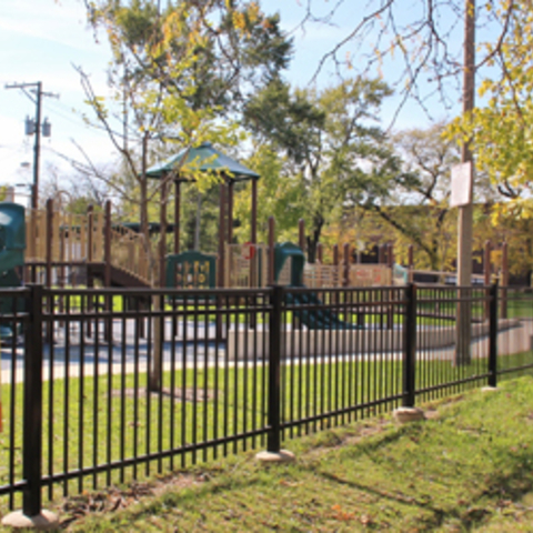 Playground enclosed by a black metal fence.