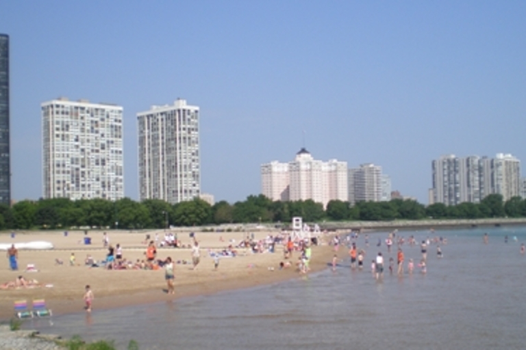 Crowded beach with high-rise buildings in the background.
