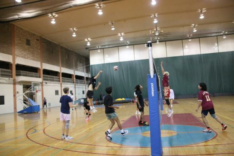 Volleyball players in action during a game in a gymnasium.