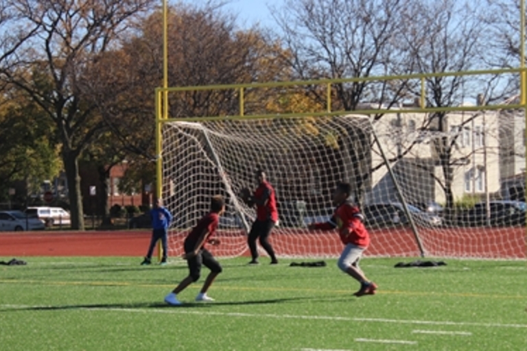 Children playing soccer on a turf field.