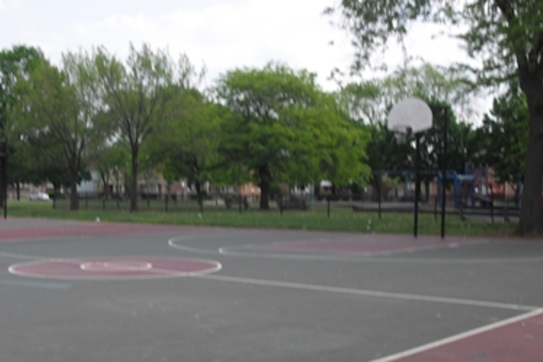 Empty outdoor basketball court on a cloudy day.