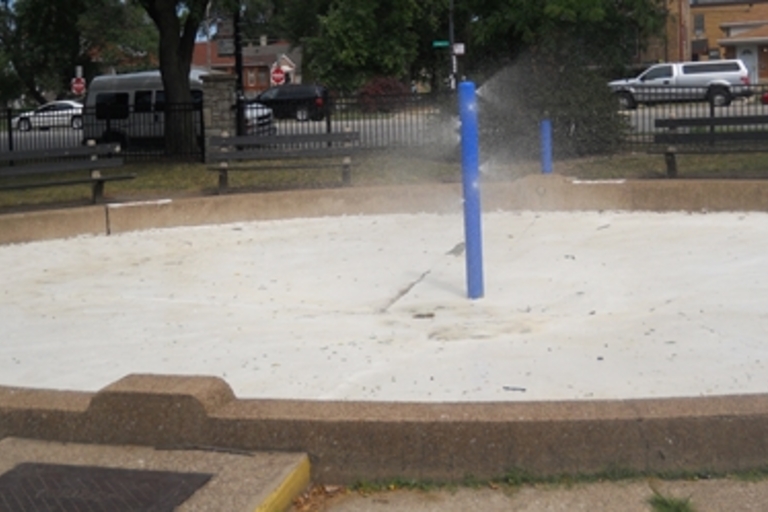 Splash pad with spraying water at a park.