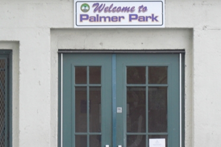 Entrance to Palmer Park building with a "Welcome to Palmer Park" sign.