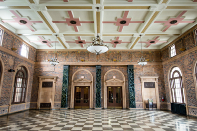 Grand hall with checkered floor and decorative ceiling.