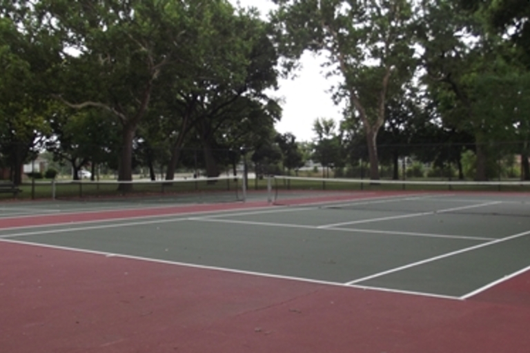 Empty tennis courts in a park.