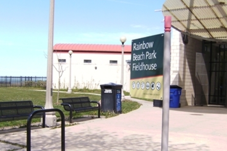 Rainbow Beach Park Fieldhouse entrance with benches and lake view.