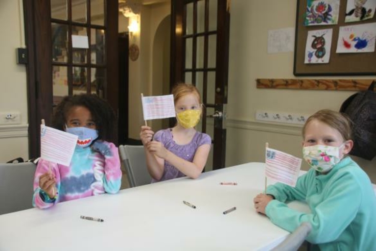 Three children hold small American flags.