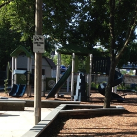 Empty playground with slides and climbing structures on a sunny day.