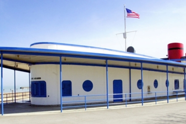 Streamlined boat-shaped building with blue and white paint, flying an American flag.